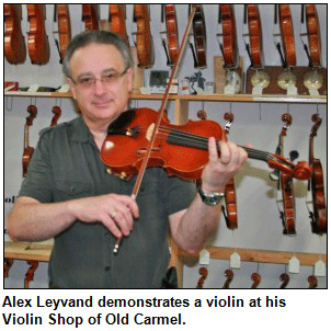 Alex Leyvand demonstrates a violin at his Violin Shop of Old Carmel.