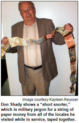 Don Shady shows a “short snorter,” which is military jargon for a string of paper money from all of the locales he visited while in service, taped together. Image courtesy Kayleen Reusser.