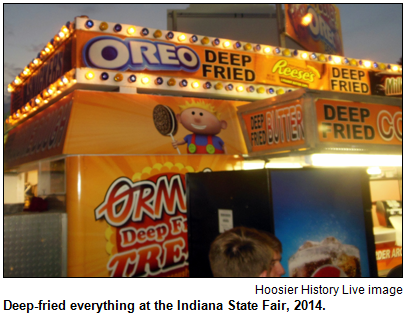 A food stand at the 2014 Indiana State Fair has signs for deep-fried Oreo, deep-fried butter and deep-fried Reeses peanut-butter cups.
