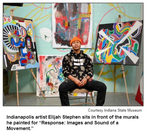 Indianapolis artist Elijah Stephen sits in front of the murals he painted for “Response: Images and Sound of a Movement.” Courtesy Indiana State Museum.
