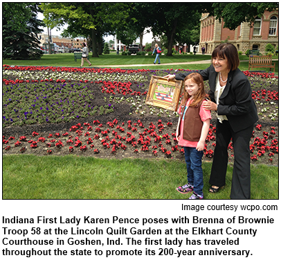 Indiana First Lady Karen Pence poses with Brenna of Brownie Troop 58 at the Lincoln Quilt Garden at the Elkhart County Courthouse in Goshen, Ind. The first lady has traveled throughout the state to promote its 200-year anniversary. Image courtesy wcpo.com.