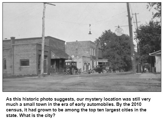 As this historic photo suggests, our mystery location was still very much a small town in the era of early automobiles. By the 2010 census, it had grown to be among the top ten largest cities in the state. What is the city?