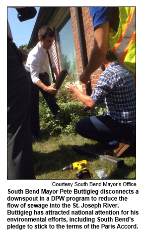 South Bend Mayor Pete Buttigieg disconnects a downspout in a DPW program to reduce the flow of sewage into the St. Joseph River. Buttigieg has attracted national attention for his environmental efforts, including South Bend’s pledge to stick to the terms of the Paris Accord. 
Courtesy South Bend Mayor's Office.