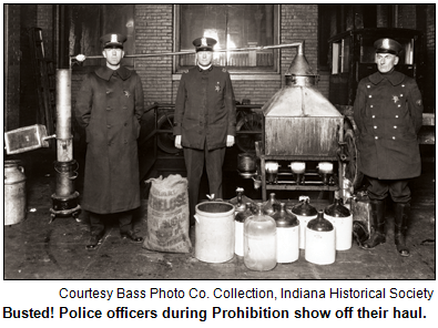 Police officers stand over illegal alcohol seized during a Prohibition-era raid. Courtesy Bass Photo Co Collection, Indiana Historical Society.