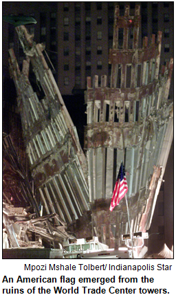 An American flag emerged from the ruins of the World Trade Center towers. Image by Mpozi Mshale Tolbert/ Indianapolis Star.