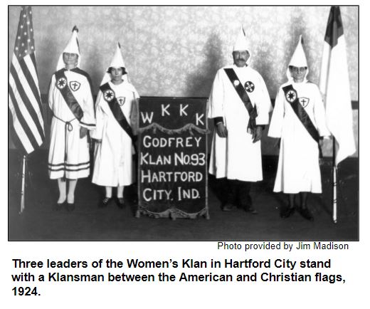 Three leaders of the Women’s Klan in Hartford City stand with a Klansman between the American and Christian flags, 1924.
Photo provided by Jim Madison.