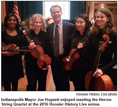 Indianapolis Mayor Joe Hogsett enjoyed meeting the Herron String Quartet at the 2016 Hoosier History Live soiree. Picture shows Hogsett and the four young women with their instruments in the wood-lined Cook Theater in the Indiana Landmarks Center in downtown Indianapolis.