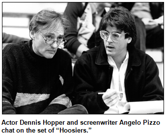 Actor Dennis Hopper and screenwriter Angelo Pizzo chat on the set of “Hoosiers.”