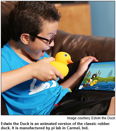 A boy is pictured with a yellow rubber duck. He is looking at a screen featuring Edwin the Duck, an animated version of the classic rubber duck, created by pi lab in Carmel, Ind.