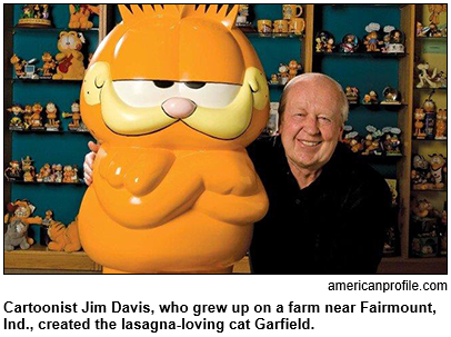 Cartoonist Jim Davis is pictured with a large statue of his lasagna-loving cat, Garfield.