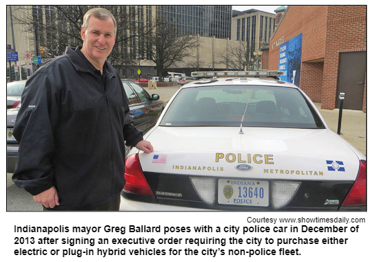Indianapolis mayor Greg Ballard poses with a city police car in December of 2013 after signing an executive order requiring the city to purchase either electric or plug-in hybrid vehicles for the city’s non-police fleet. Courtesy www.showtimesdaily.com